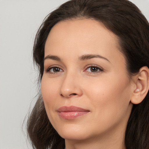 Joyful white young-adult female with long  brown hair and brown eyes