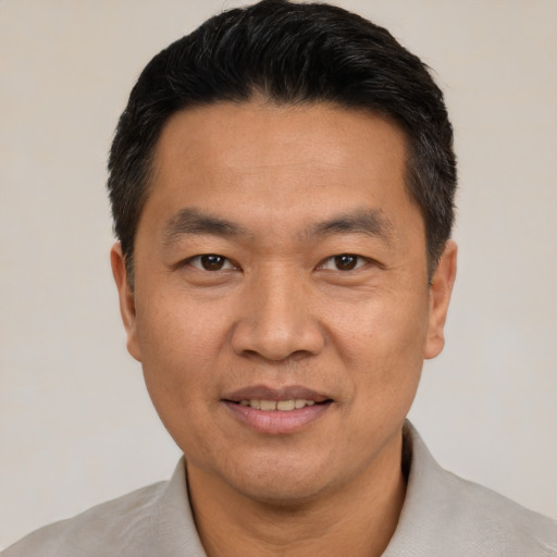 Joyful white adult male with short  black hair and brown eyes