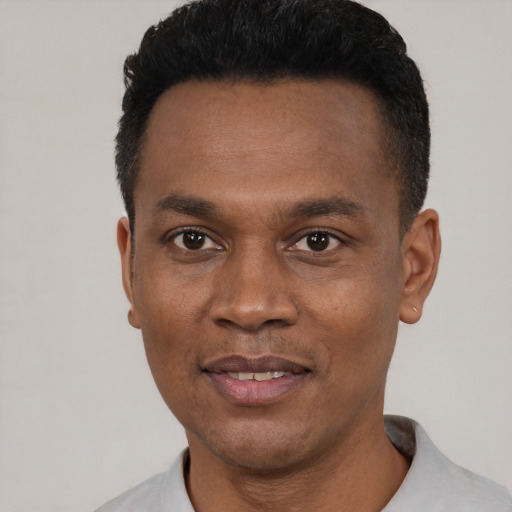 Joyful black young-adult male with short  black hair and brown eyes