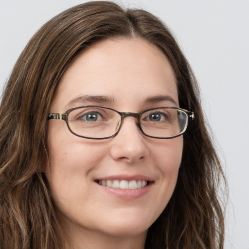 Joyful white young-adult female with long  brown hair and blue eyes