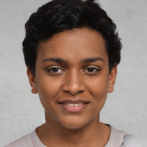 Joyful black young-adult female with short  black hair and brown eyes