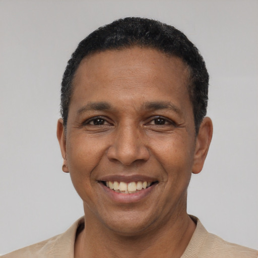 Joyful black young-adult male with short  black hair and brown eyes