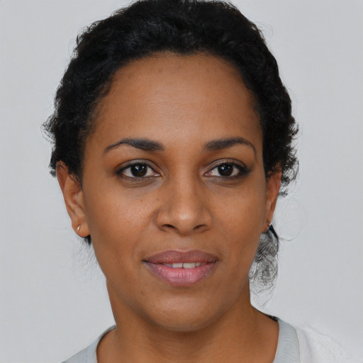 Joyful black young-adult female with short  brown hair and brown eyes