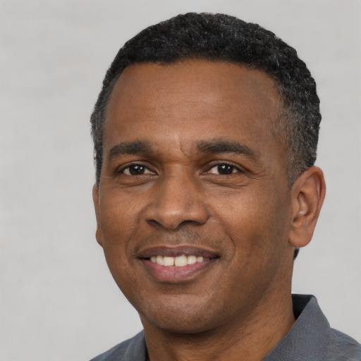 Joyful black adult male with short  black hair and brown eyes
