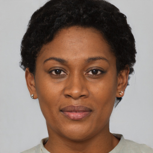 Joyful black young-adult female with short  black hair and brown eyes