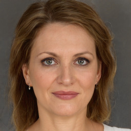 Joyful white adult female with medium  brown hair and grey eyes