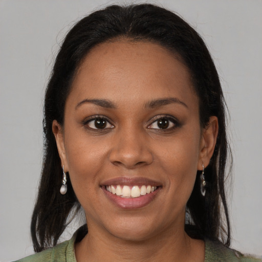 Joyful black young-adult female with long  brown hair and brown eyes