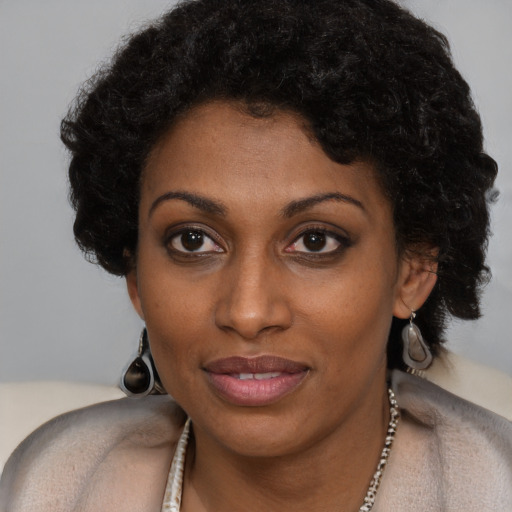 Joyful black young-adult female with short  black hair and brown eyes