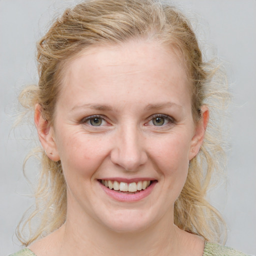 Joyful white young-adult female with medium  brown hair and blue eyes