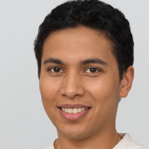 Joyful latino young-adult male with short  brown hair and brown eyes