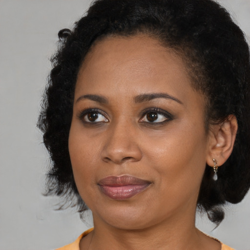 Joyful black young-adult female with medium  brown hair and brown eyes