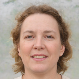 Joyful white adult female with medium  brown hair and blue eyes