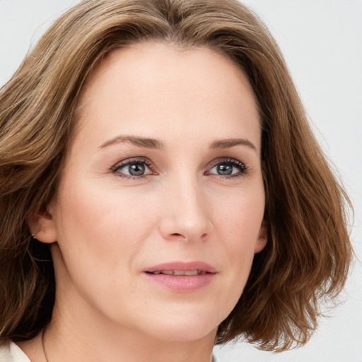 Joyful white young-adult female with medium  brown hair and blue eyes