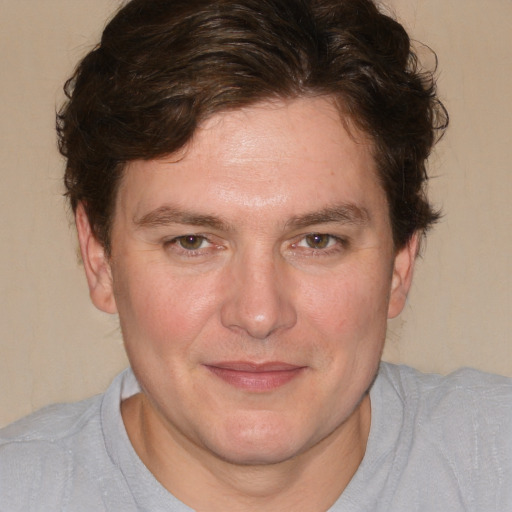 Joyful white young-adult male with short  brown hair and blue eyes