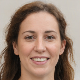 Joyful white adult female with long  brown hair and grey eyes