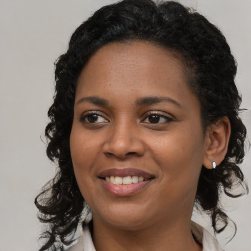 Joyful black young-adult female with medium  brown hair and brown eyes