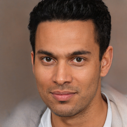 Joyful white young-adult male with short  black hair and brown eyes