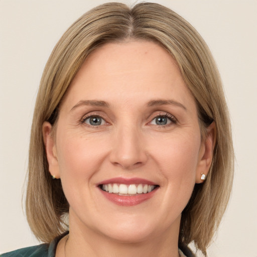 Joyful white adult female with medium  brown hair and green eyes