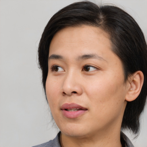 Joyful asian young-adult female with medium  brown hair and brown eyes