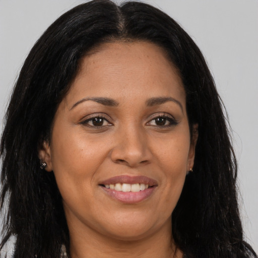 Joyful latino young-adult female with long  brown hair and brown eyes