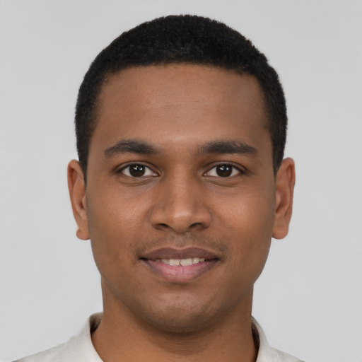 Joyful black young-adult male with short  brown hair and brown eyes