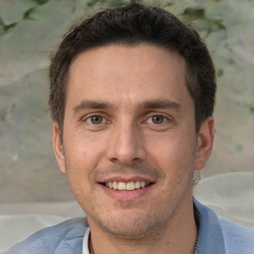 Joyful white adult male with short  brown hair and brown eyes