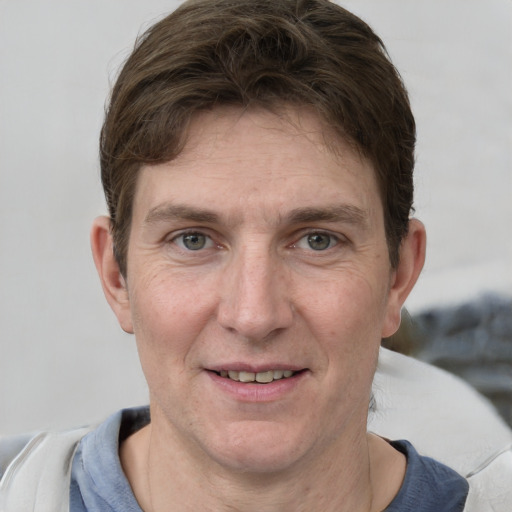 Joyful white adult male with short  brown hair and grey eyes