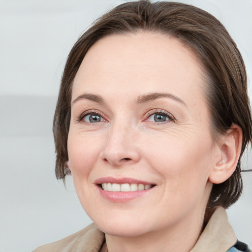 Joyful white adult female with medium  brown hair and grey eyes