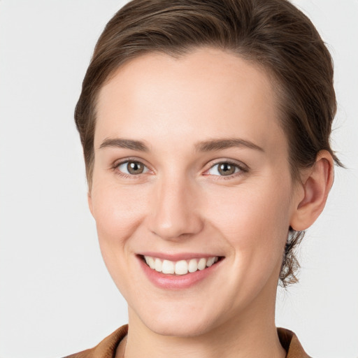 Joyful white young-adult female with short  brown hair and grey eyes