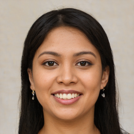 Joyful latino young-adult female with long  brown hair and brown eyes