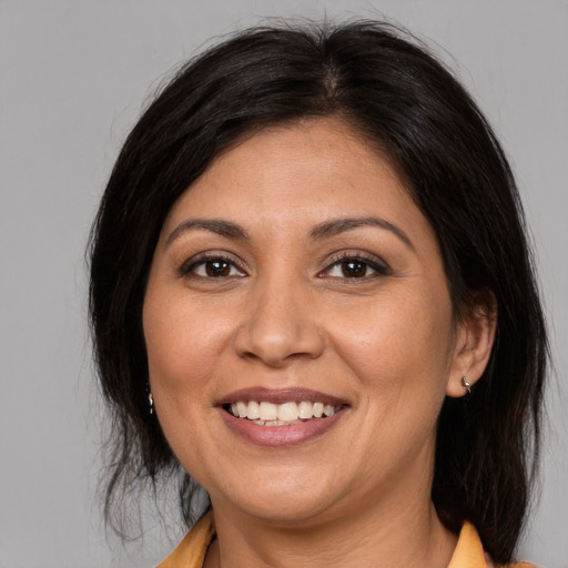 Joyful white adult female with medium  brown hair and brown eyes