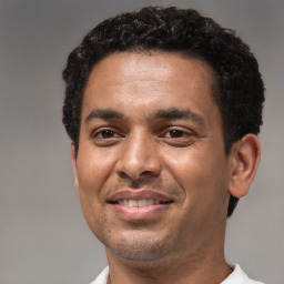 Joyful latino young-adult male with short  brown hair and brown eyes