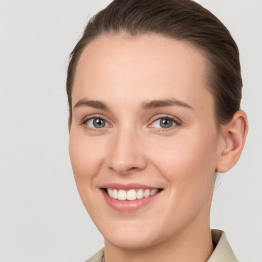 Joyful white young-adult female with short  brown hair and grey eyes