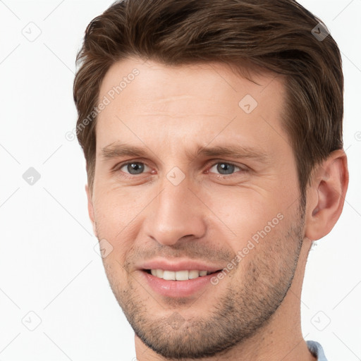 Joyful white young-adult male with short  brown hair and grey eyes