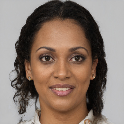 Joyful black adult female with medium  brown hair and brown eyes