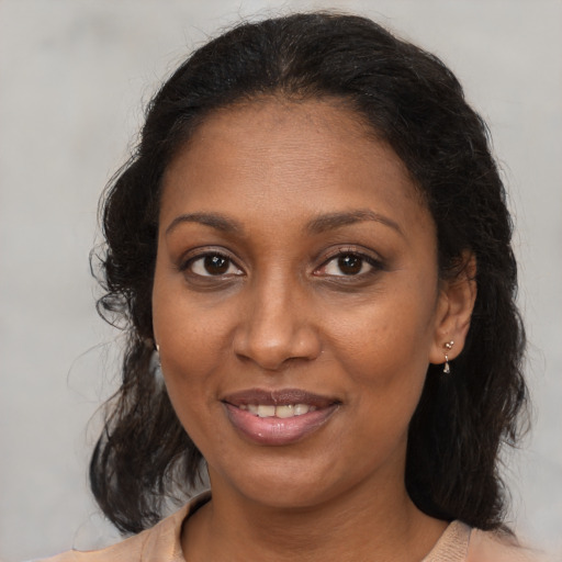 Joyful black adult female with medium  brown hair and brown eyes