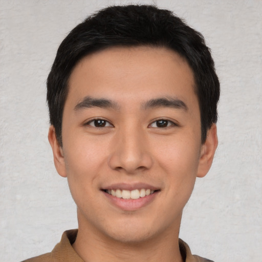 Joyful asian young-adult male with short  black hair and brown eyes