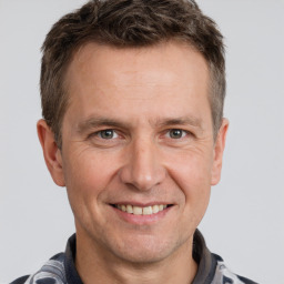 Joyful white adult male with short  brown hair and grey eyes