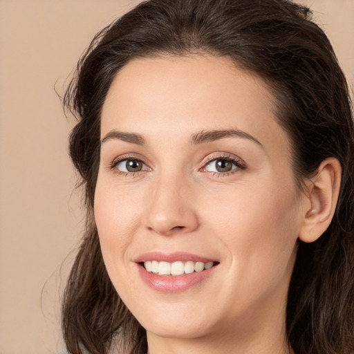 Joyful white young-adult female with long  brown hair and brown eyes