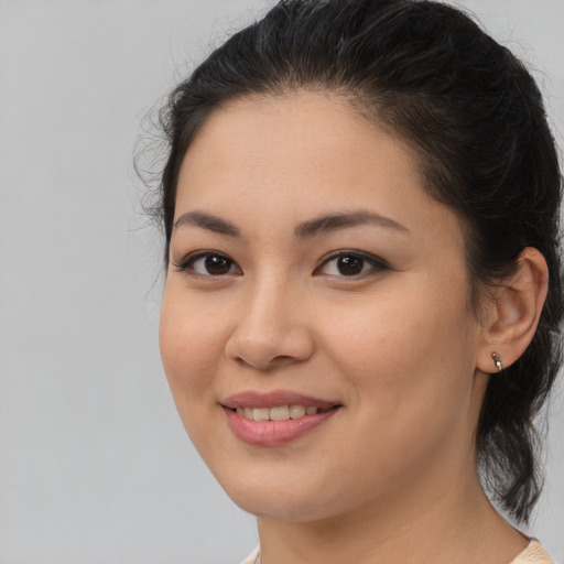 Joyful latino young-adult female with medium  brown hair and brown eyes