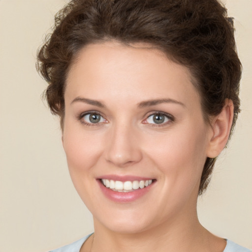 Joyful white young-adult female with short  brown hair and green eyes