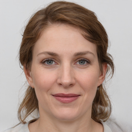 Joyful white young-adult female with medium  brown hair and grey eyes