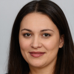 Joyful white adult female with long  brown hair and brown eyes