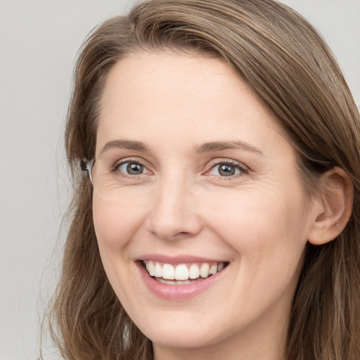 Joyful white young-adult female with long  brown hair and grey eyes