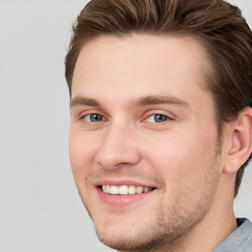 Joyful white young-adult male with short  brown hair and grey eyes