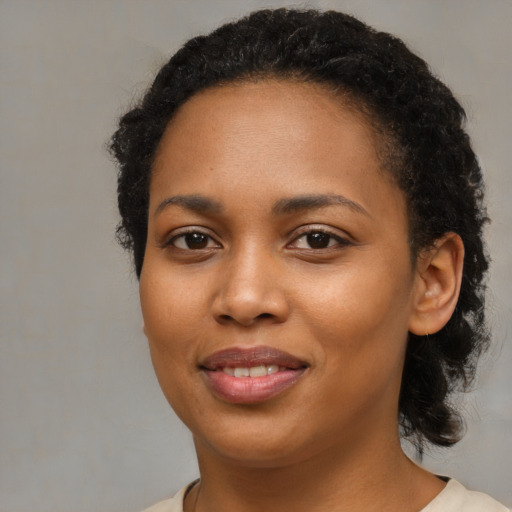 Joyful black young-adult female with medium  brown hair and brown eyes