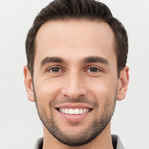 Joyful white young-adult male with short  brown hair and brown eyes