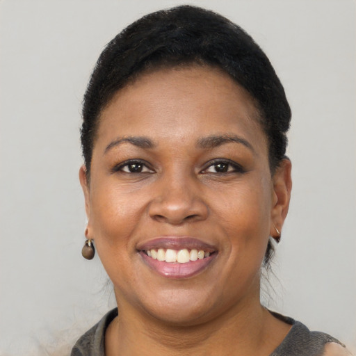 Joyful black young-adult female with short  black hair and brown eyes