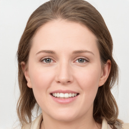 Joyful white young-adult female with medium  brown hair and grey eyes