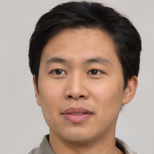 Joyful asian young-adult male with short  brown hair and brown eyes